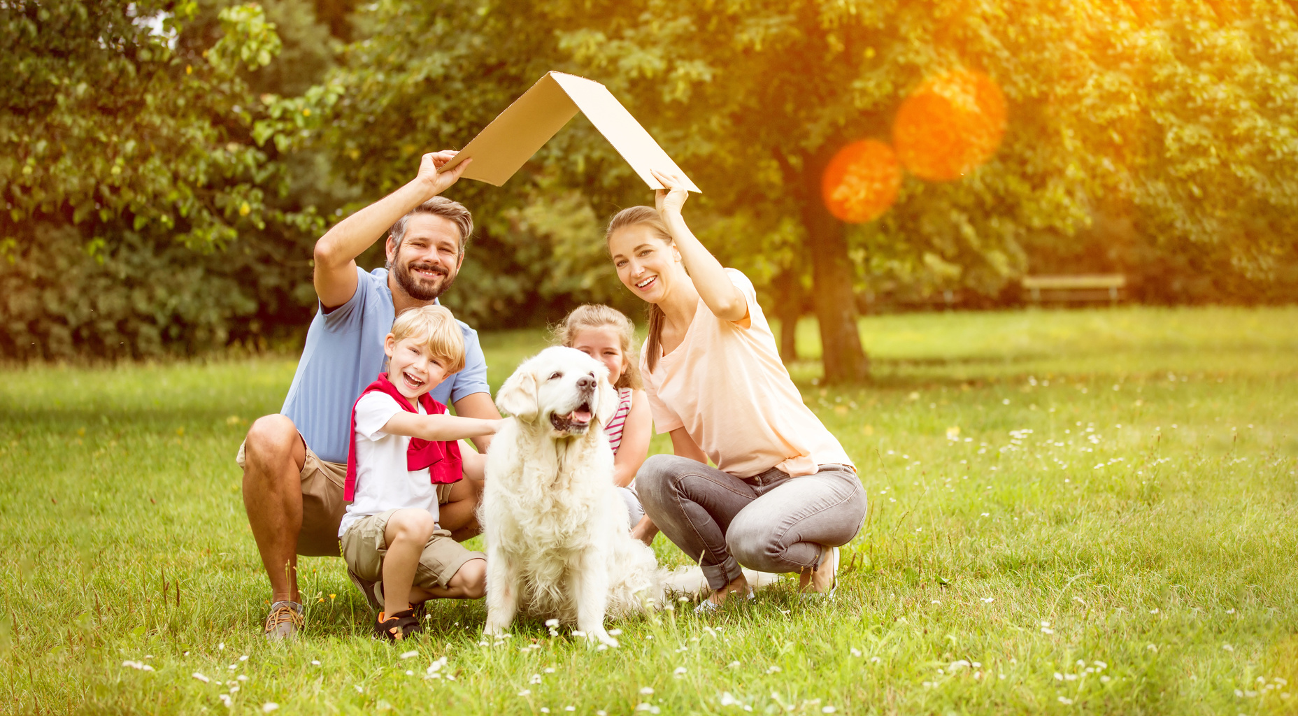 Familie steht gemeinsam unter einem schützenden Hausdach